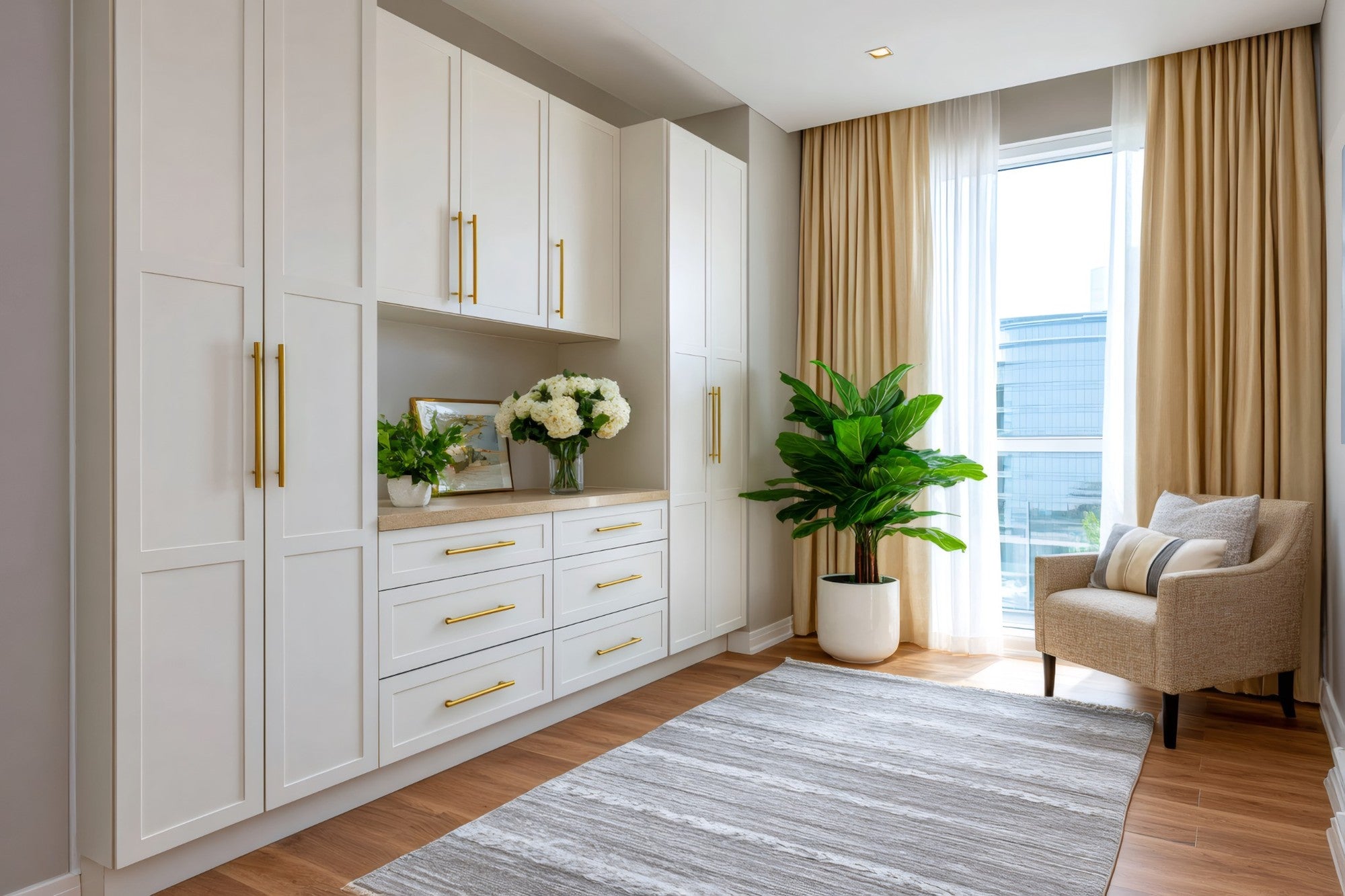 Legacy White Shaker storage cabinets and closet organization system with gold hardware and natural wood flooring
