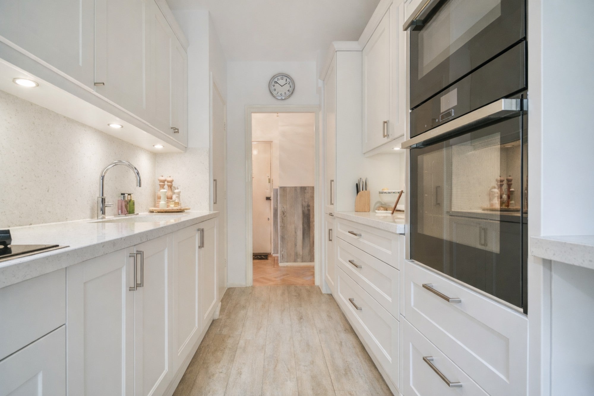 Legacy White Shaker galley kitchen with white cabinets, quartz countertops and built-in appliances